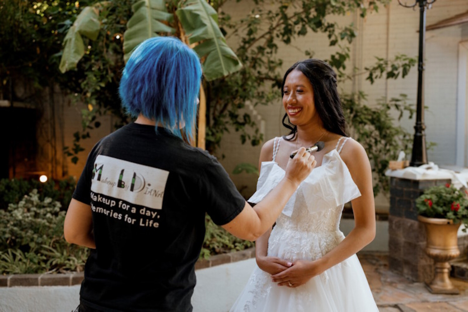 Professional Arizona bridal makeup artist Diana from Makeup by Diana applying foundation to a bride during outdoor wedding preparation