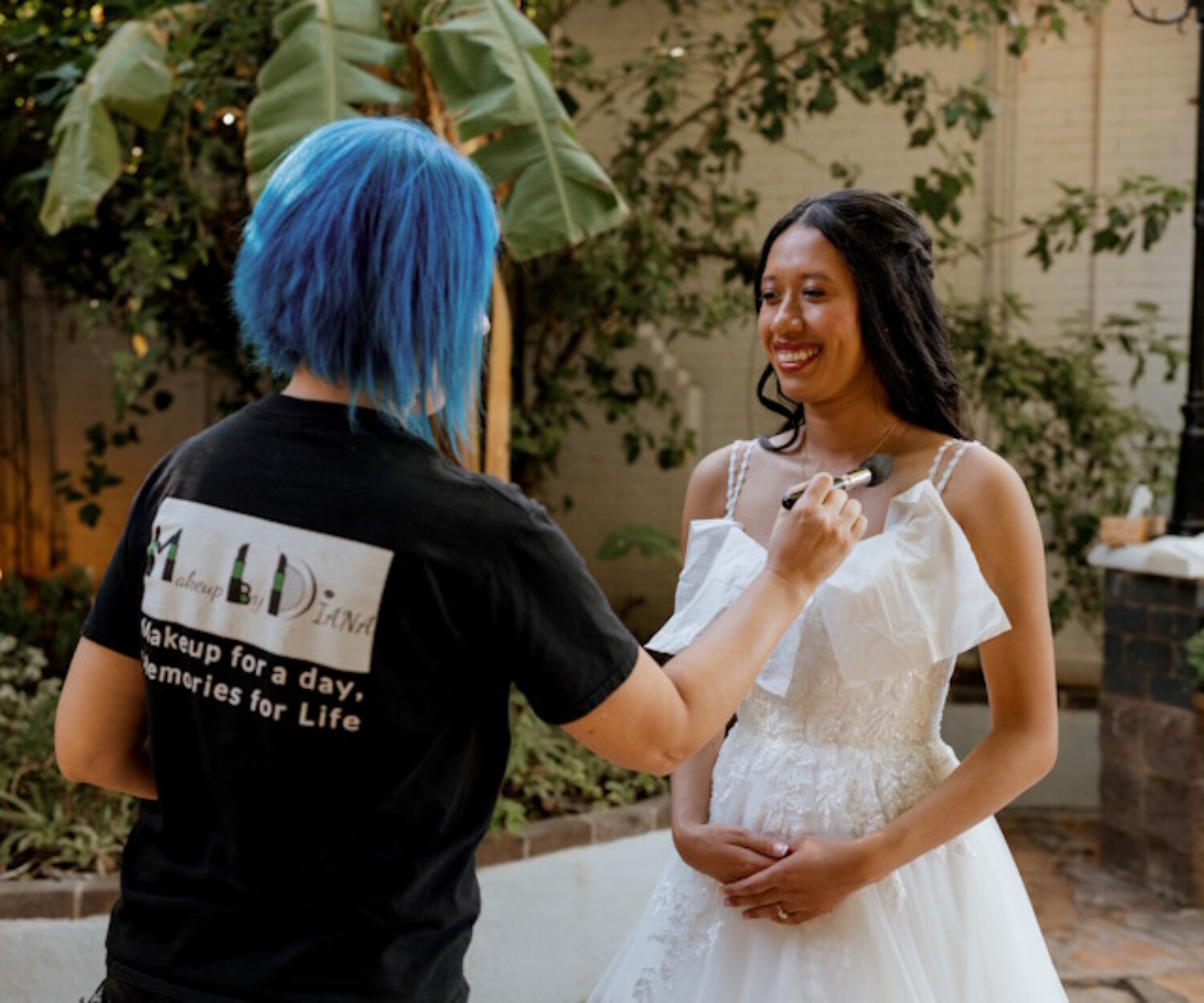 Professional Arizona bridal makeup artist Diana from Makeup by Diana applying foundation to a bride during outdoor wedding preparation