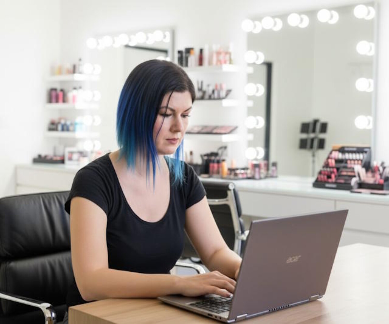 Arizona mobile makeup artist managing makeup appointments on a laptop in a professional beauty studio.