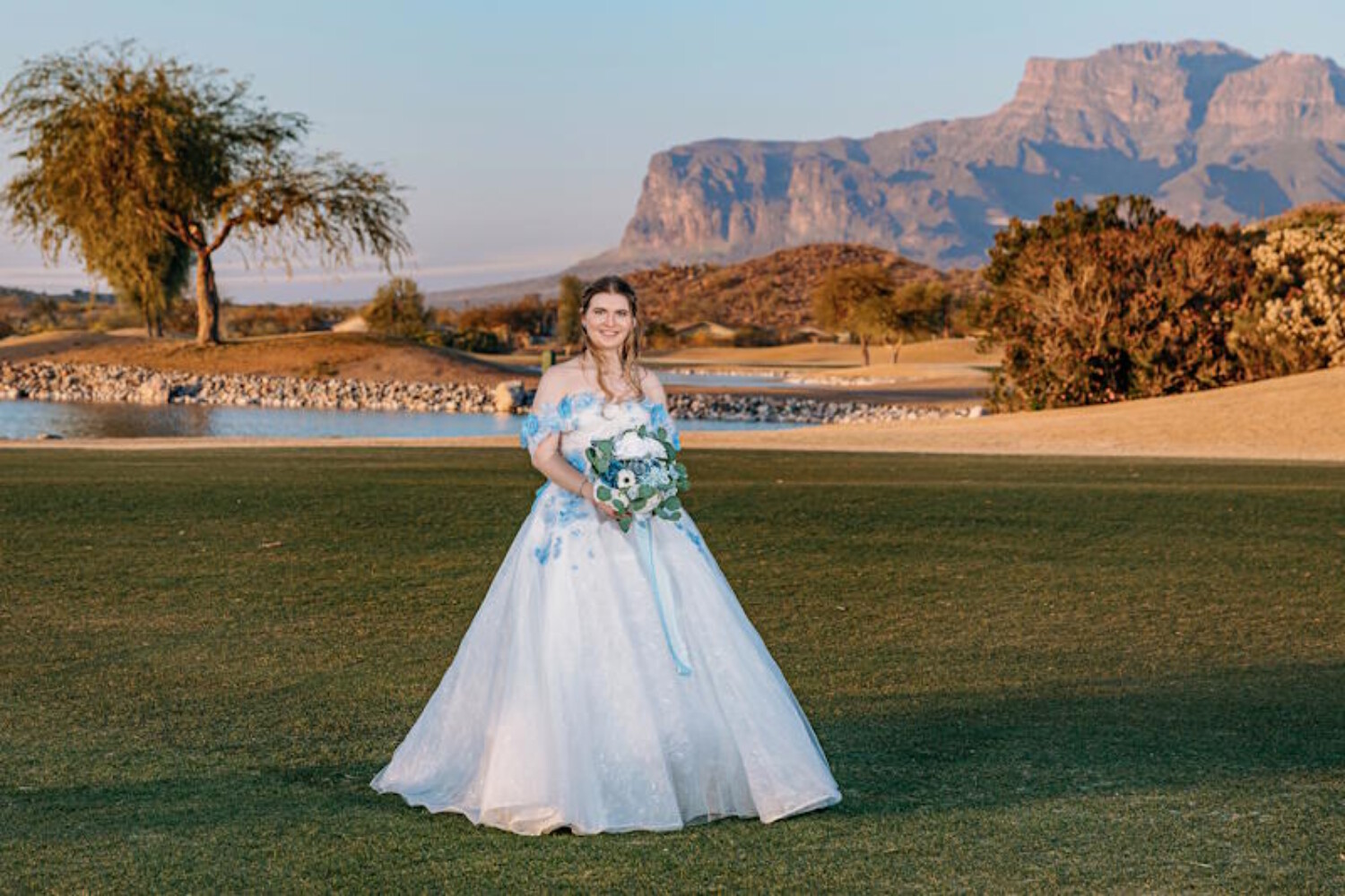 Phoenix bridal makeup artist Diana creates a natural, long-lasting wedding day look for a bride in a blue floral gown on an Arizona golf course during golden hour.