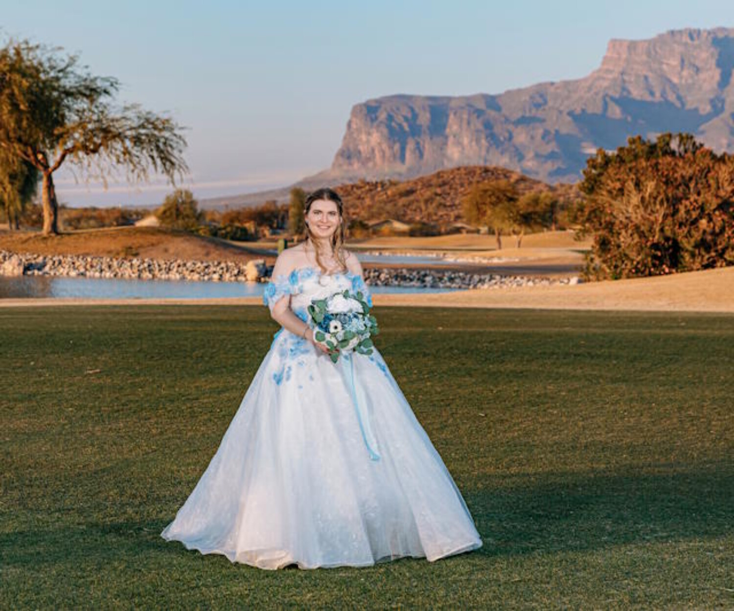 Phoenix bridal makeup artist Diana creates a natural, long-lasting wedding day look for a bride in a blue floral gown on an Arizona golf course during golden hour.