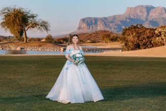 Phoenix bridal makeup artist Diana creates a natural, long-lasting wedding day look for a bride in a blue floral gown on an Arizona golf course during golden hour.