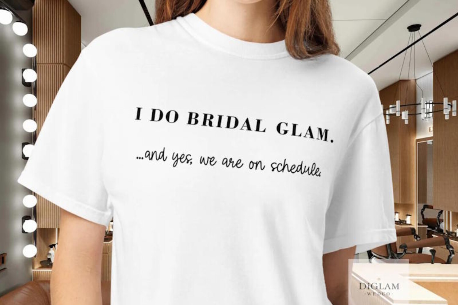 Makeup artist wearing a wedding‑day bridal glam shirt in a professional salon setting – DiGlamWedCo beauty professional attire.