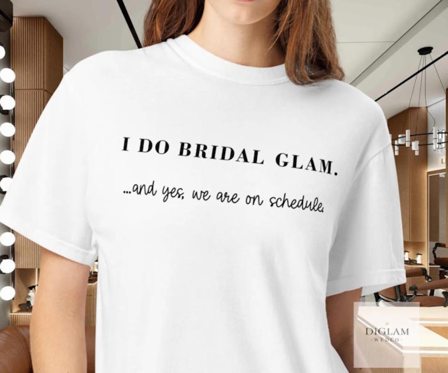Makeup artist wearing a wedding‑day bridal glam shirt in a professional salon setting – DiGlamWedCo beauty professional attire.