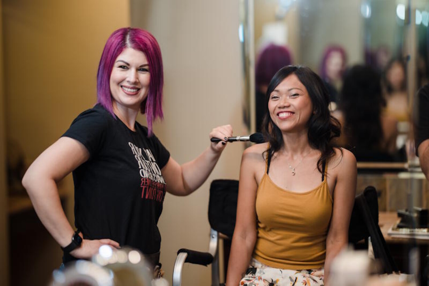 Bridal makeup artist in Chandler AZ smiling with a happy client during a makeup session - Makeup by Diana