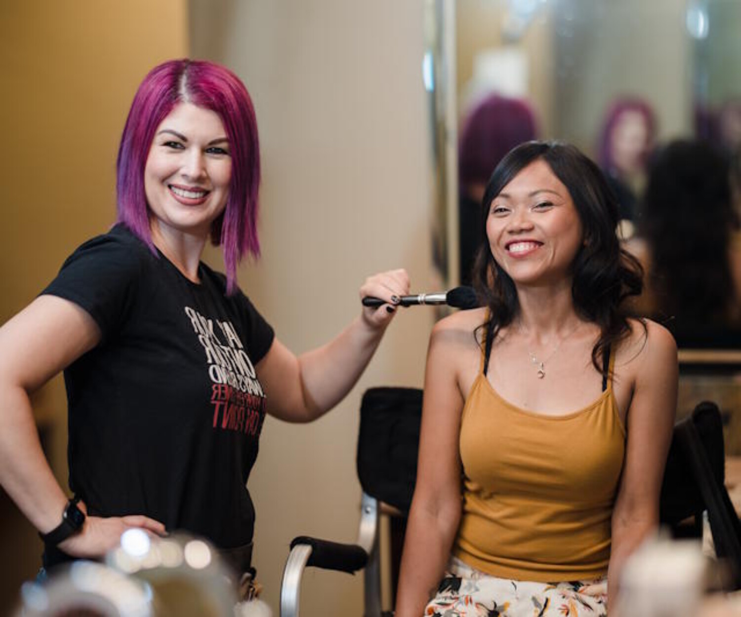 Bridal makeup artist in Chandler AZ smiling with a happy client during a makeup session - Makeup by Diana