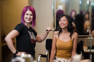 Bridal makeup artist in Chandler AZ smiling with a happy client during a makeup session - Makeup by Diana